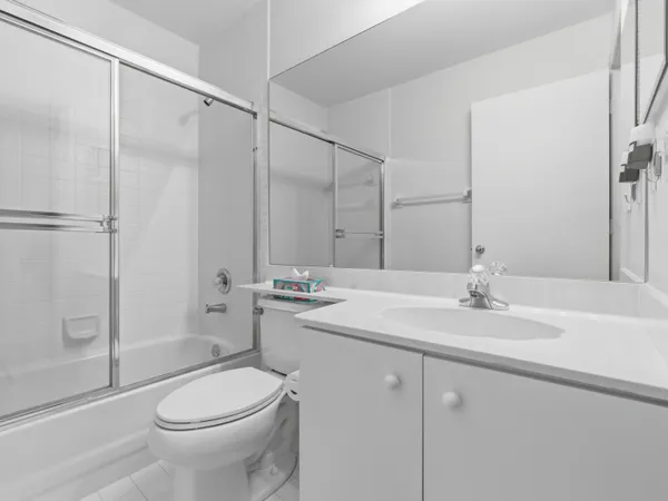 a bathroom with a granite countertop sink a toilet and a shower