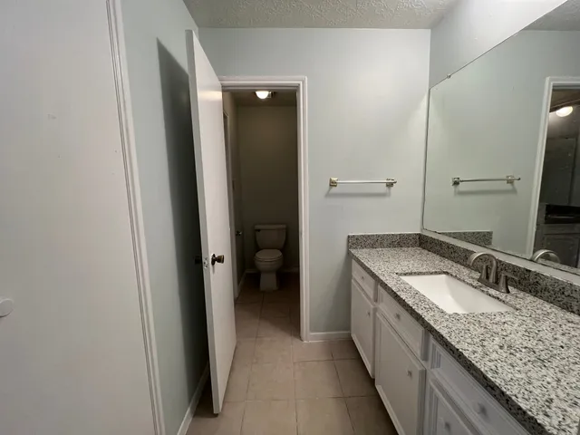 a bathroom with a granite countertop sink and a mirror