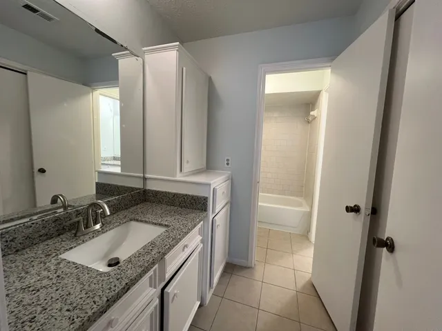 a bathroom with a granite countertop sink and a mirror