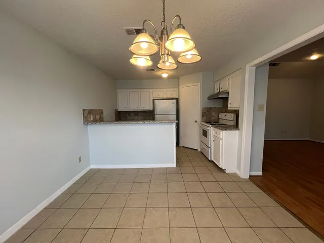 a kitchen with a sink a stove cabinets and a counter top space