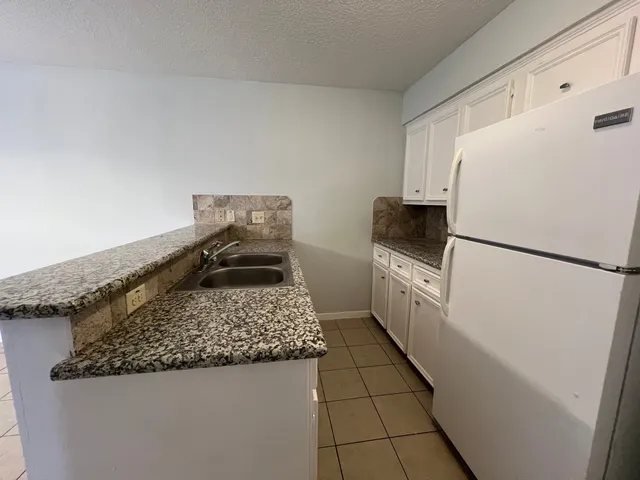a kitchen with a refrigerator and a stove