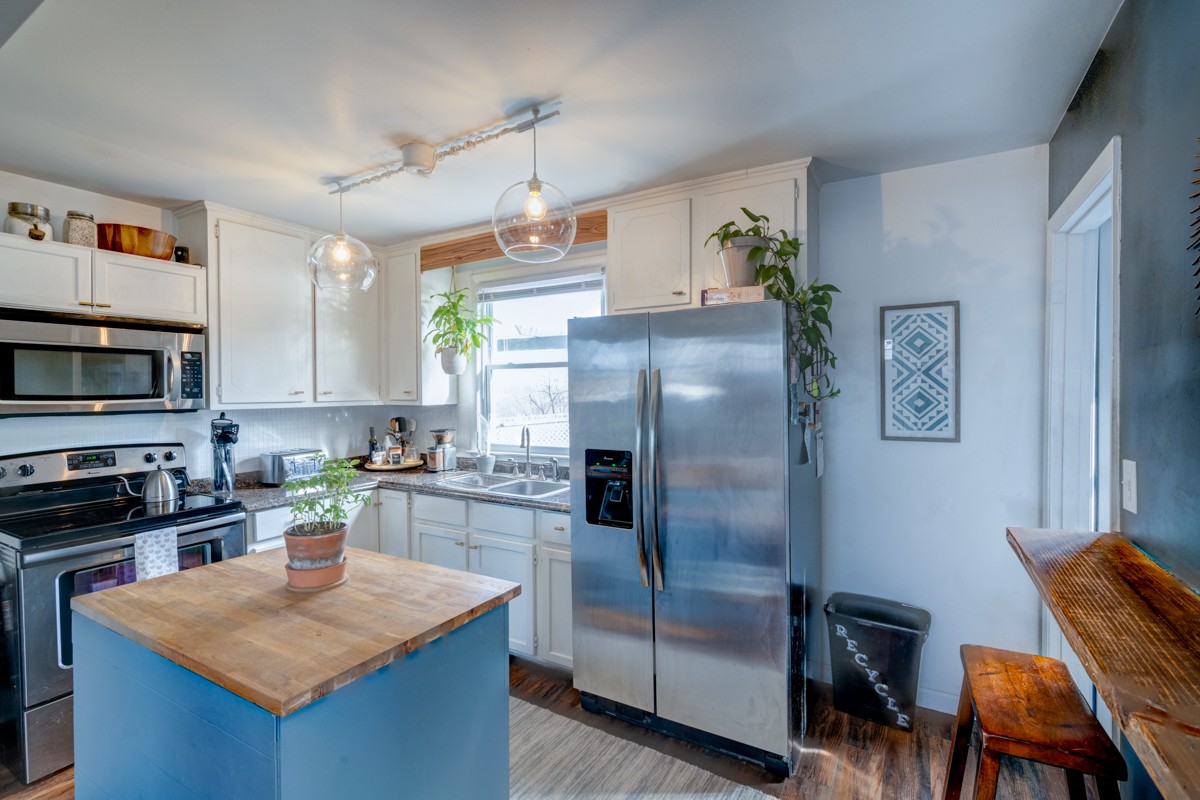 1447 Dolan Road Nashville, TN 37218 - Photo 6 of 20 a kitchen with stainless steel appliances granite countertop a refrigerator a stove a sink a dining table and chairs with wooden floor