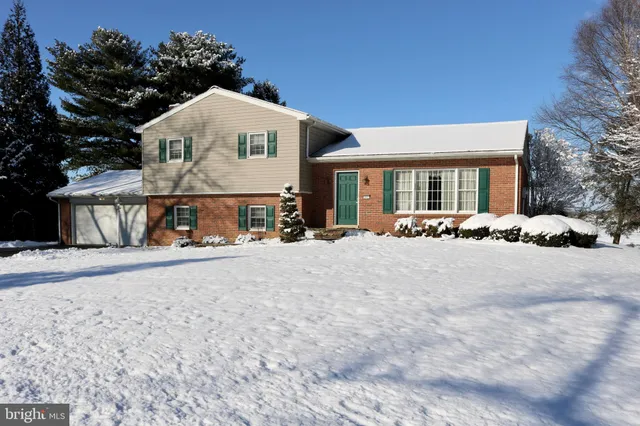 a view of a house with snow on the side of road