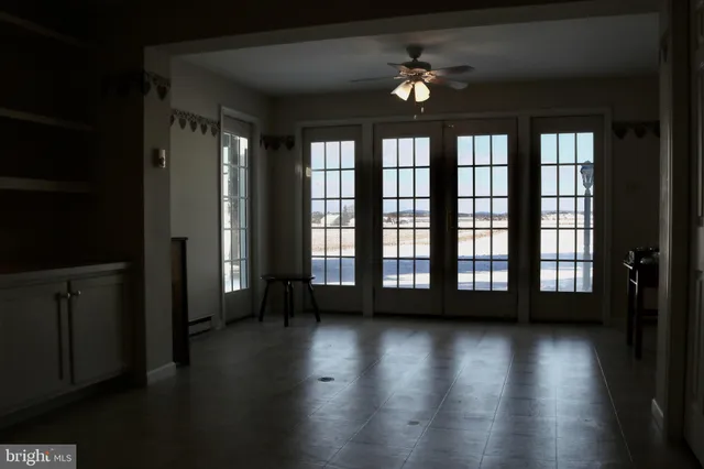 a view of big room with wooden floor and windows