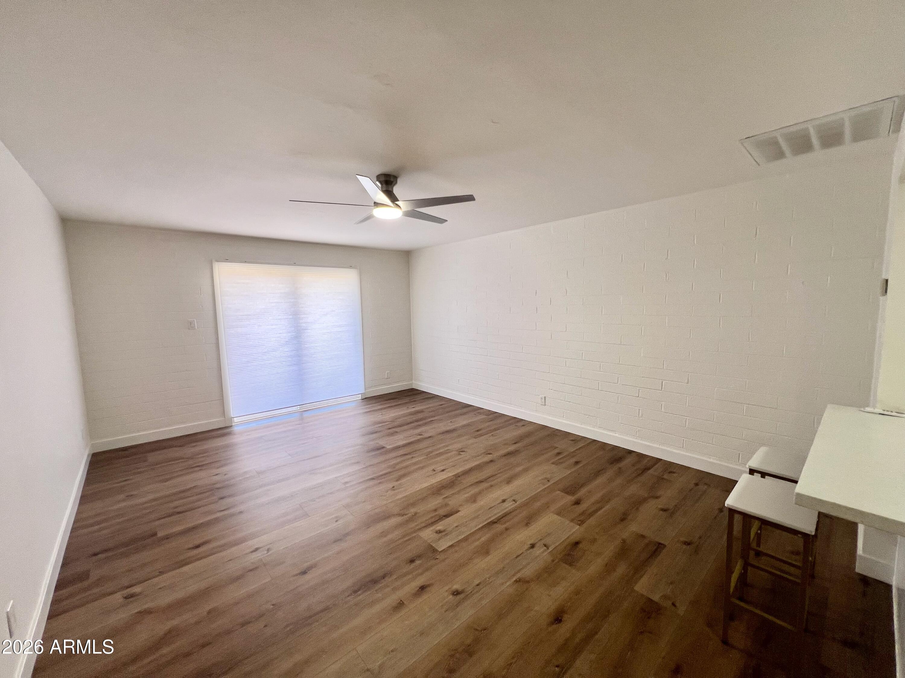 3818 West Ruth Avenue Phoenix, AZ 85051 - Photo 8 of 20 a view of an empty room with wooden floor