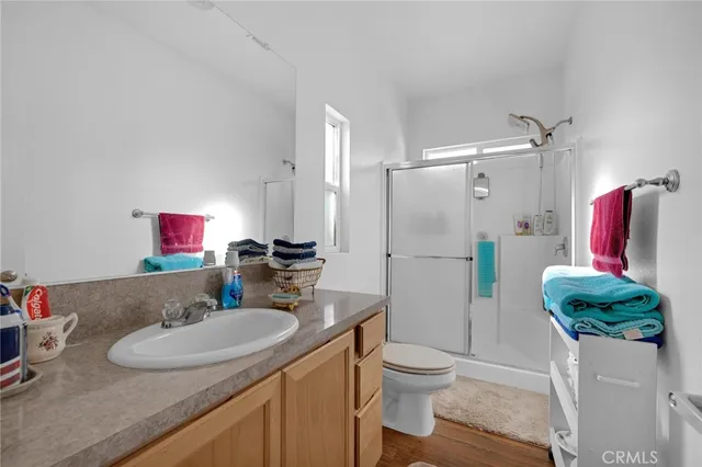 a bathroom with a granite countertop sink a toilet and shower