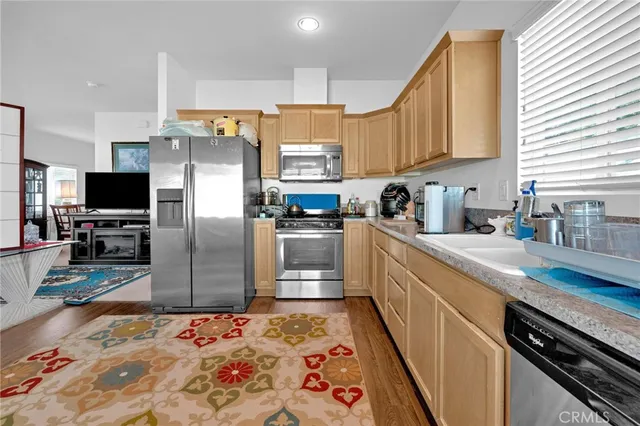a kitchen with stainless steel appliances kitchen island granite countertop a sink refrigerator and microwave
