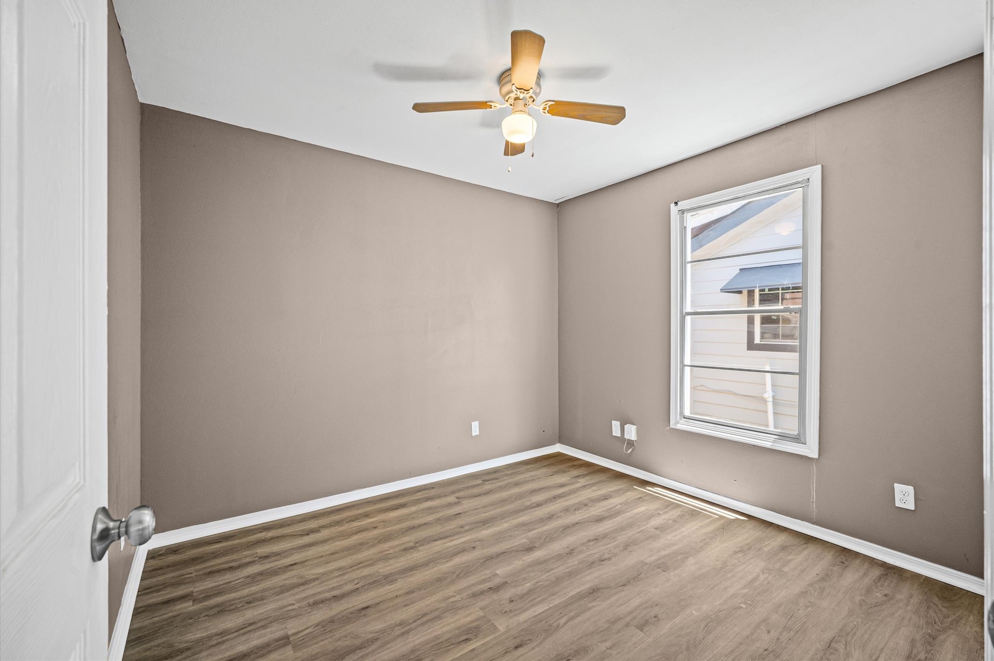 10621 Lane Street Houston, TX 77029 - Photo 13 of 29 an empty room with windows and a ceiling fan