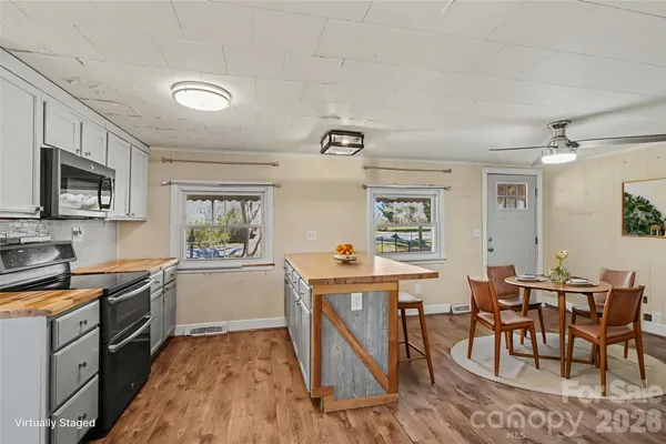 a kitchen with a table chairs microwave and cabinets