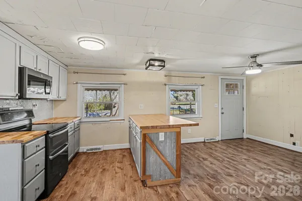 a kitchen that has a lot of cabinets in it and wooden floors