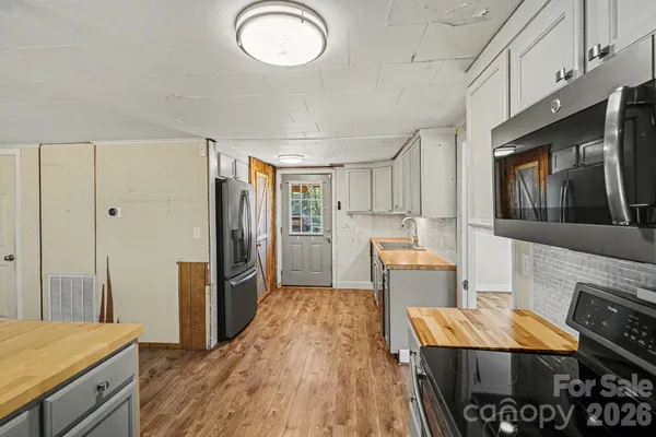 a kitchen with stainless steel appliances kitchen island granite countertop a refrigerator and a stove top oven