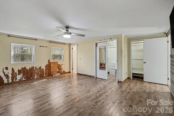 an empty room with closet and windows