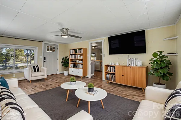 a living room with furniture a flat screen tv and a large window