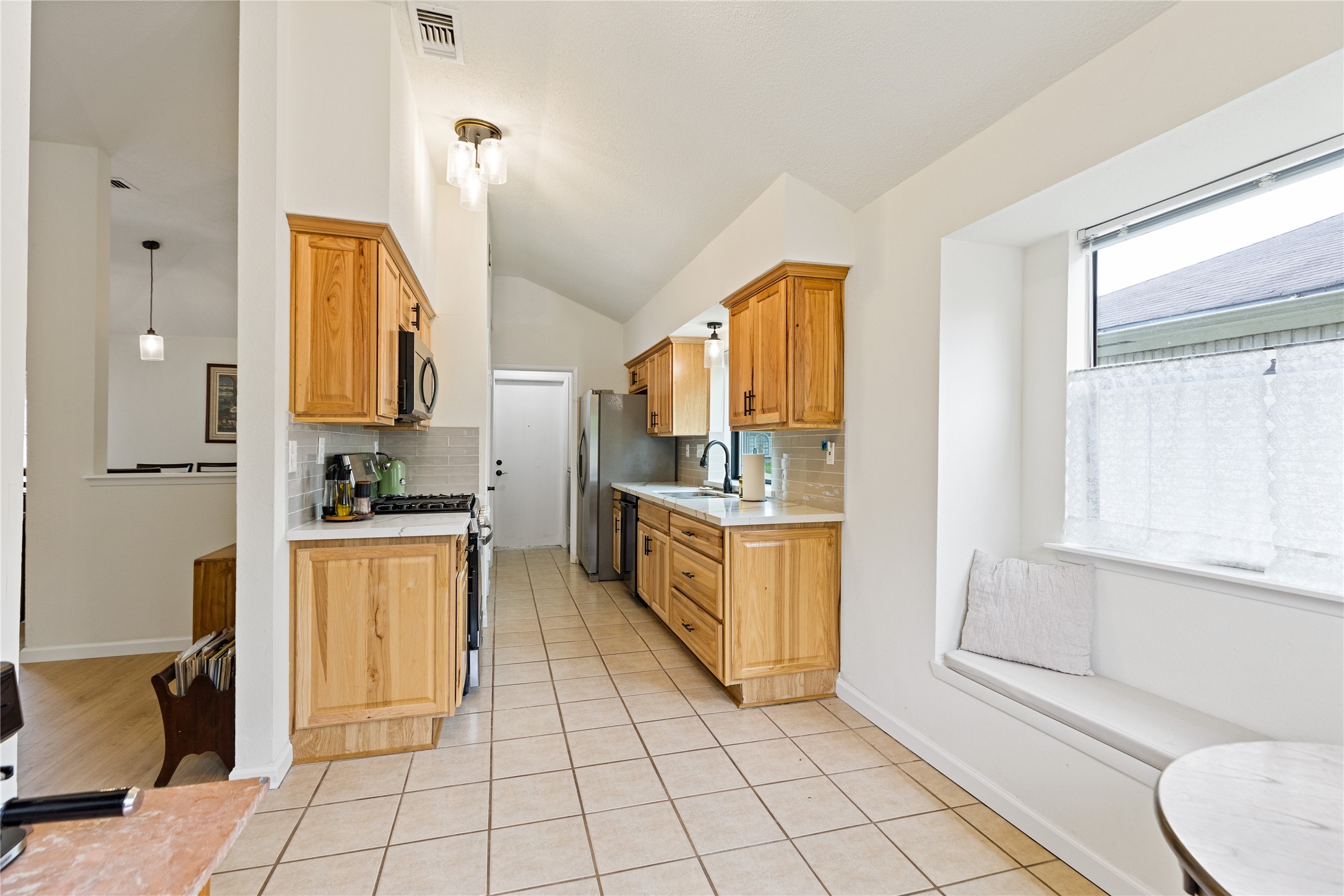 9719 Orangevale Drive Spring, TX 77379 - Photo 16 of 32 Image of kitchen from breakfast room offering attractive bench seats under large windows.