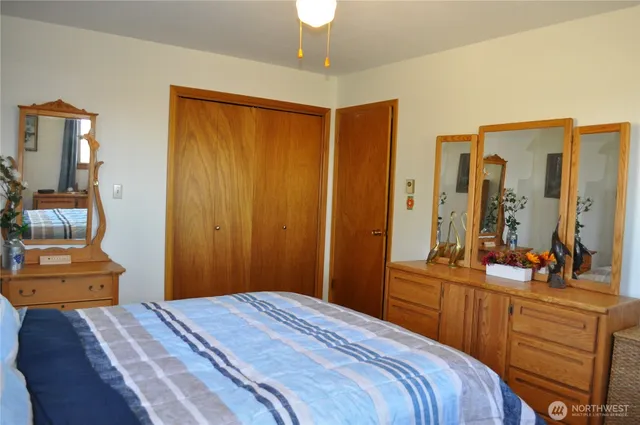 a bedroom with a bed and a mirror on dresser