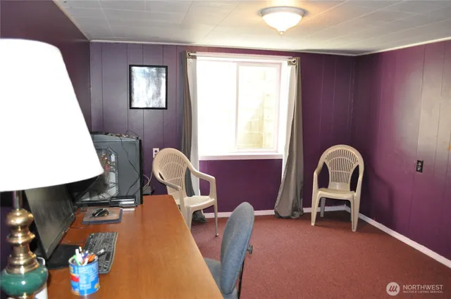 a view of a workspace with furniture and a window