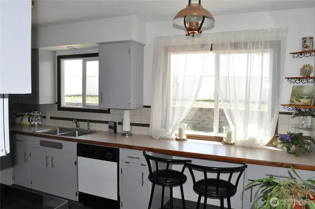 a kitchen with a table chairs sink and cabinets