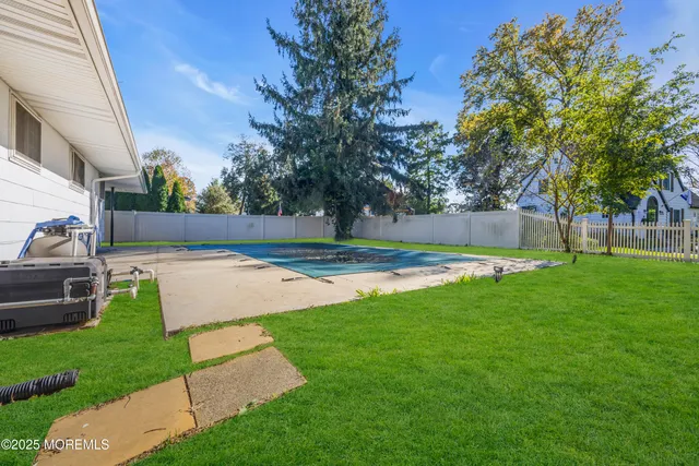 a view of yard with swimming pool and green space