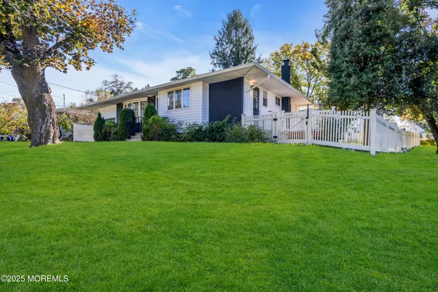a house that has a big yard with wooden fence