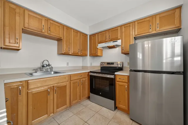 a kitchen with granite countertop wooden cabinets and a sink
