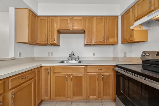 a kitchen with cabinets appliances a sink and a counter top