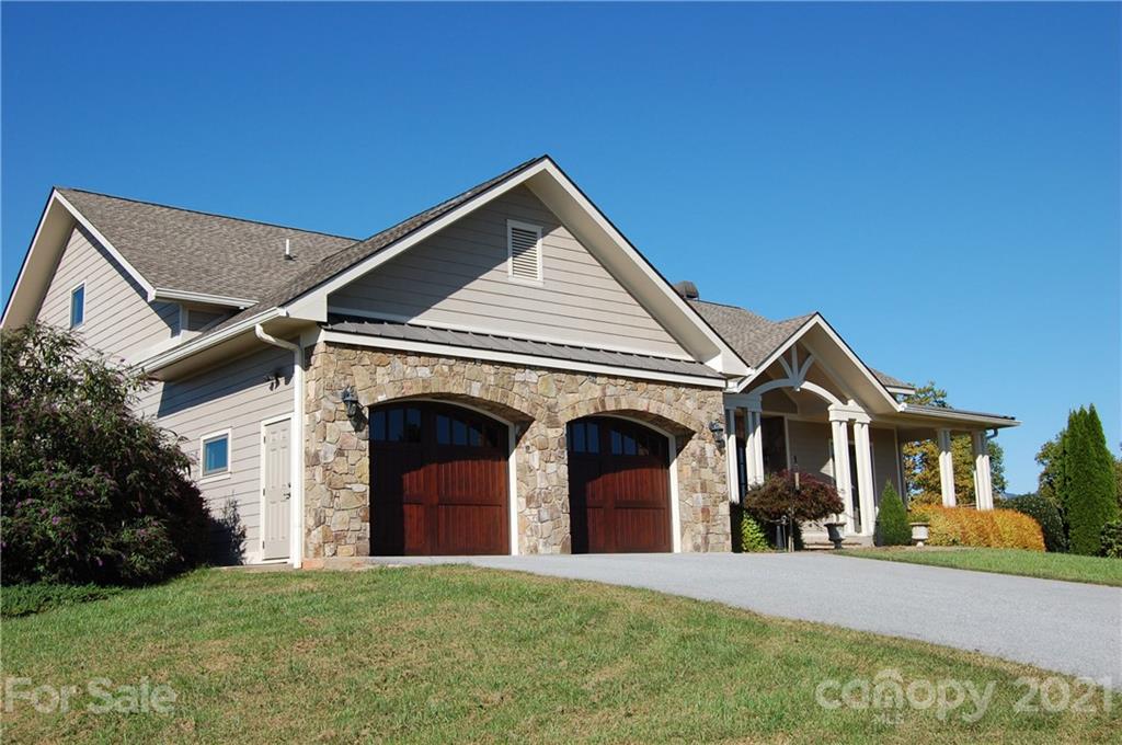 352 Windflower Ln Mill Spring Tryon, NC 28782 - Photo 1 of 43 a front view of a house with a garden and yard