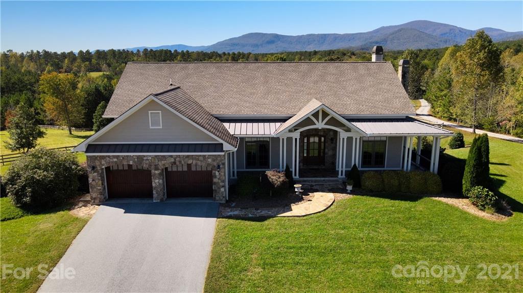 352 Windflower Ln Mill Spring Tryon, NC 28782 - Photo 2 of 43 a front view of a house with a yard and mountain view