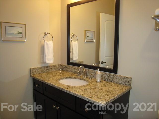 352 Windflower Ln Mill Spring Tryon, NC 28782 - Photo 25 of 43 a bathroom with a granite countertop sink and a mirror