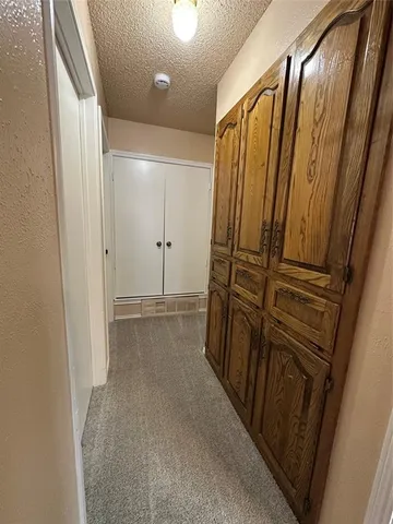 an empty room with a chandelier fan and windows