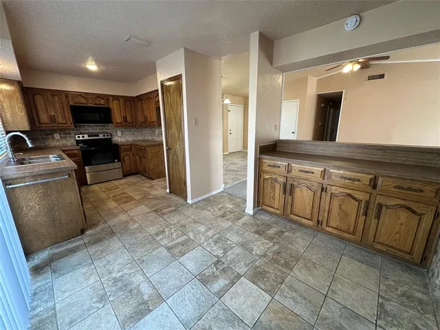 a kitchen with stainless steel appliances granite countertop a sink and cabinets