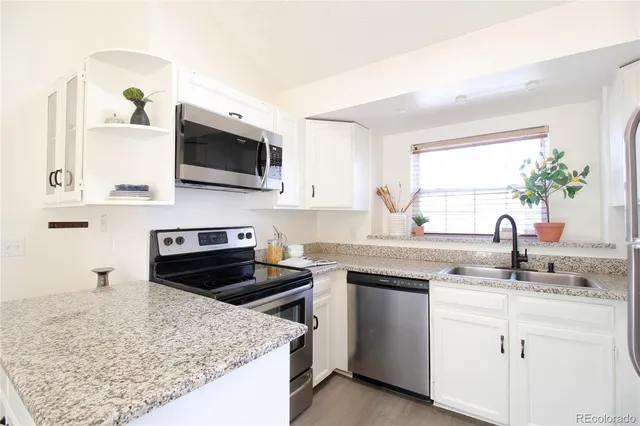 a kitchen with a sink stove top oven and microwave