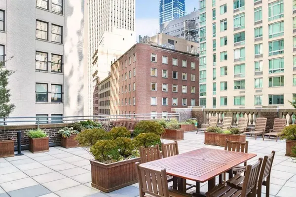 a view of a patio with a table and chairs and potted plants
