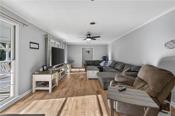 a living room with furniture a chandelier and a floor to ceiling window
