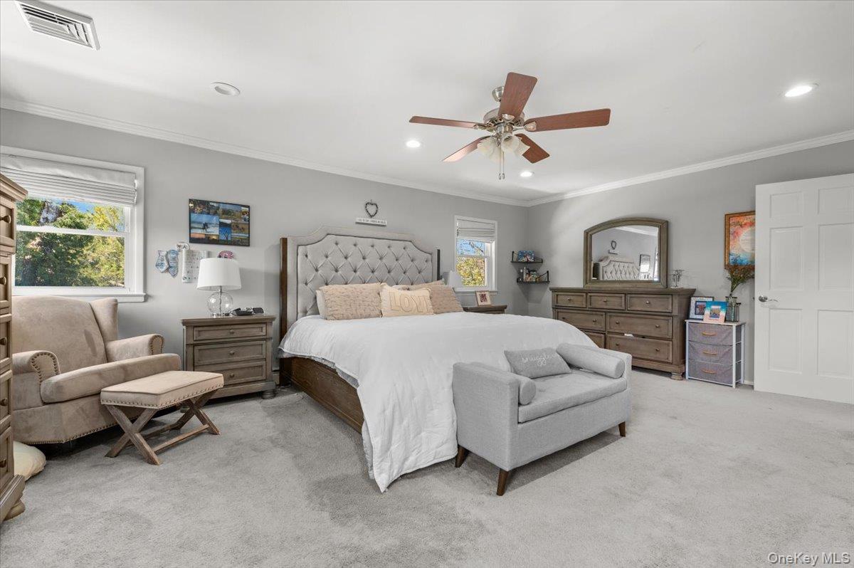 61 Winthrop Road Plainview, NY 11803 - Photo 14 of 37 a spacious bedroom with a bed a couch and a ceiling fan