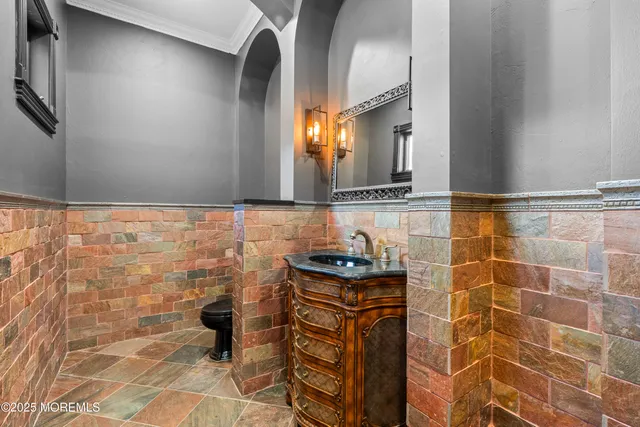 a bathroom with a granite countertop sink a toilet and a mirror