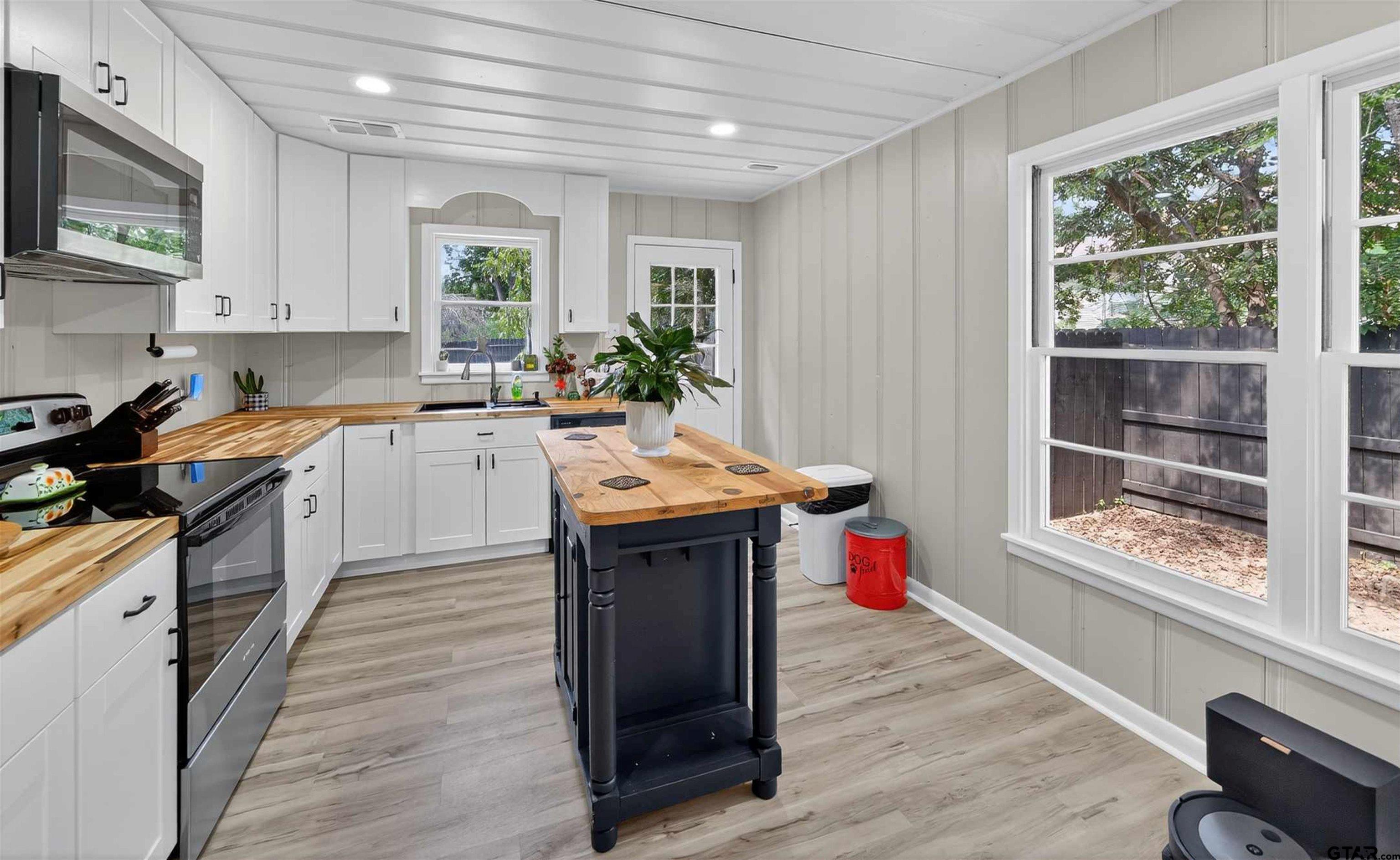 105 Holcomb Street Frankston, TX 75763 - Photo 5 of 13 a kitchen with a sink dishwasher stove and wooden cabinets