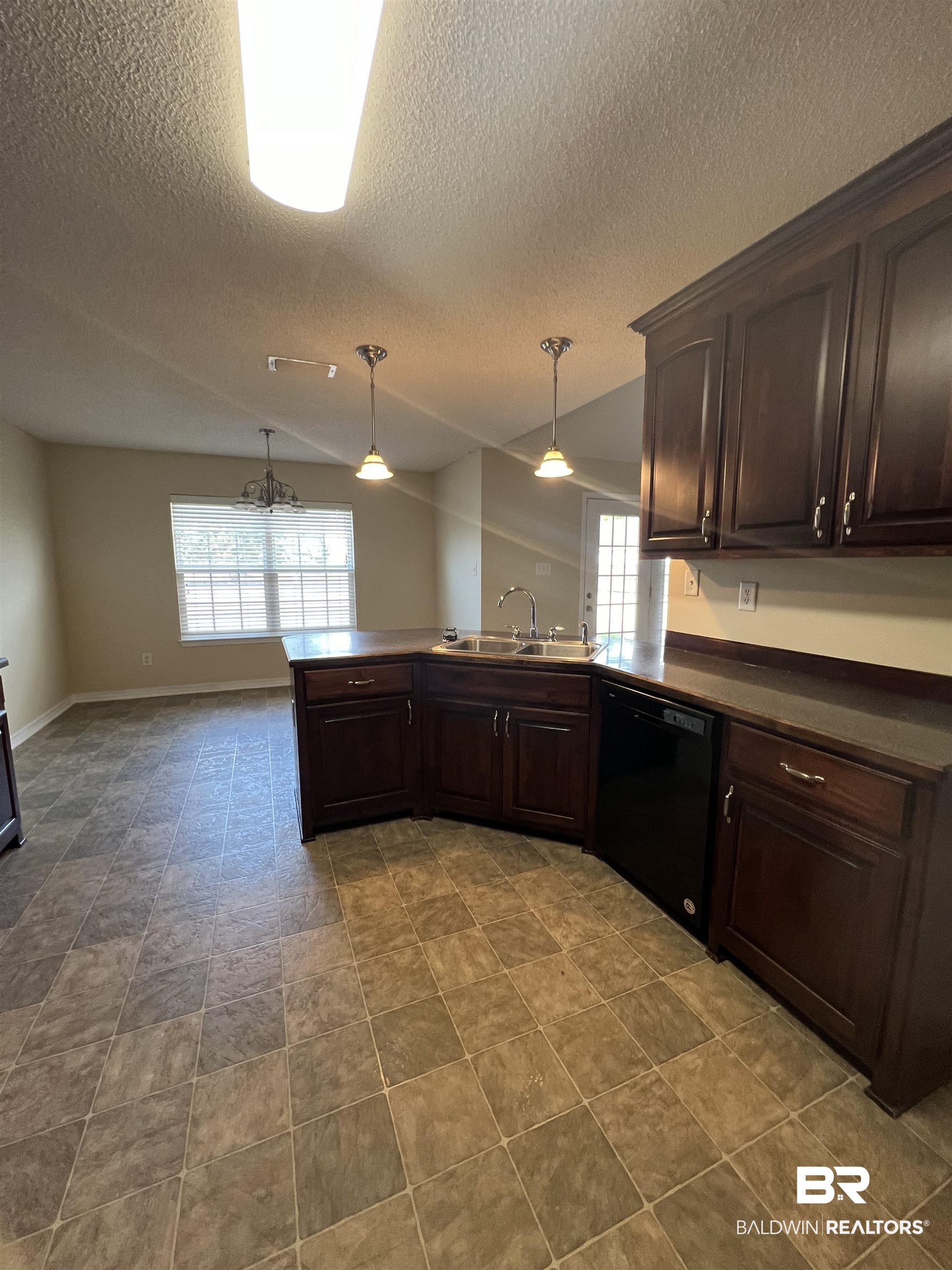 17793 Fancy Boulevard Foley, AL 36535 - Photo 7 of 34 Kitchen with dishwasher, sink, hanging light fixtures, dark brown cabinetry, and kitchen peninsula