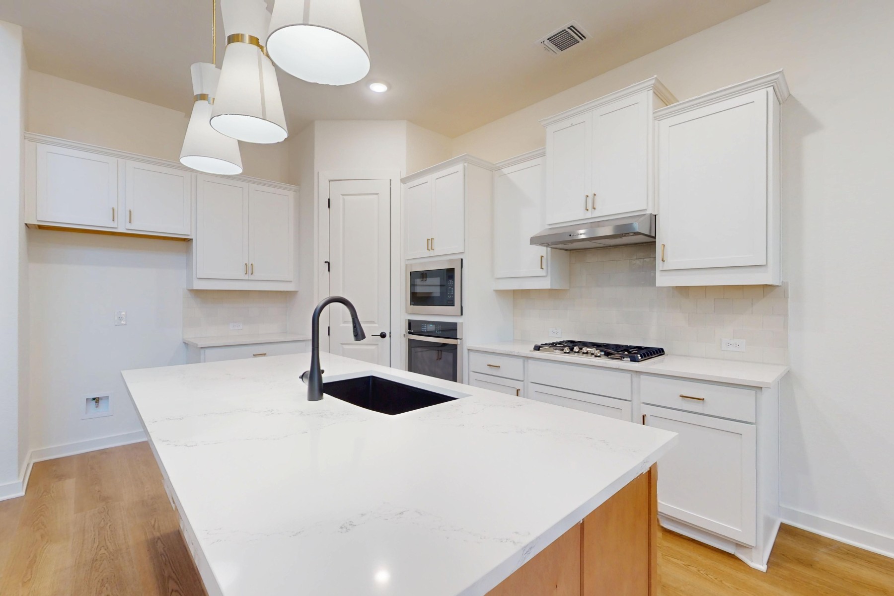 3613 Helena Way Leander, TX 78641 - Photo 8 of 27 a kitchen with stainless steel appliances a sink a stove and white cabinets