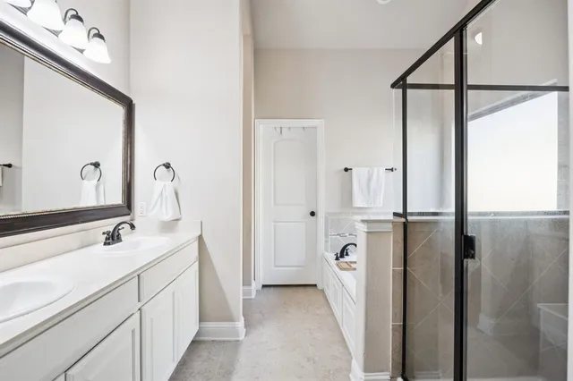 a bathroom with a double vanity sink a mirror and shower