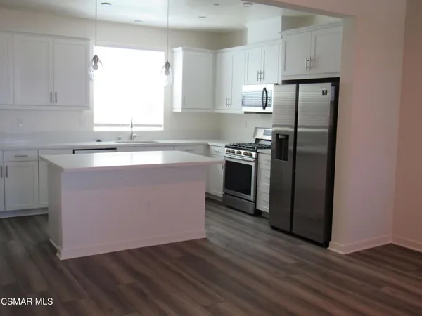 a view of a kitchen with wooden floor and a sink
