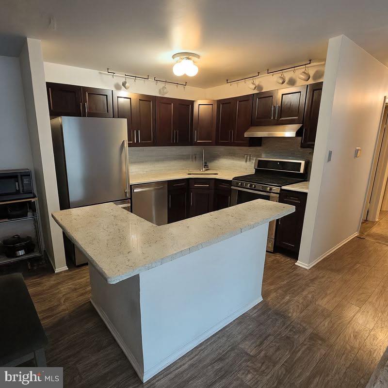 a kitchen with stainless steel appliances a refrigerator a stove a sink and a refrigerator