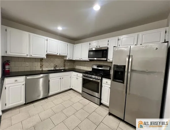 a kitchen with granite countertop cabinets stainless steel appliances and a counter space