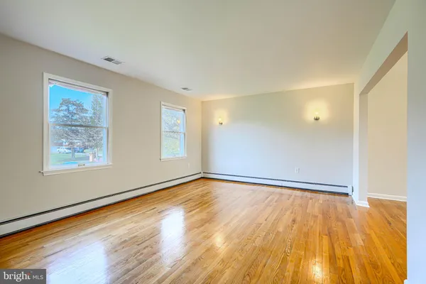 a view of empty room with wooden floor