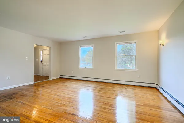 a kitchen with granite countertop a refrigerator a sink dishwasher and white cabinets with wooden floor