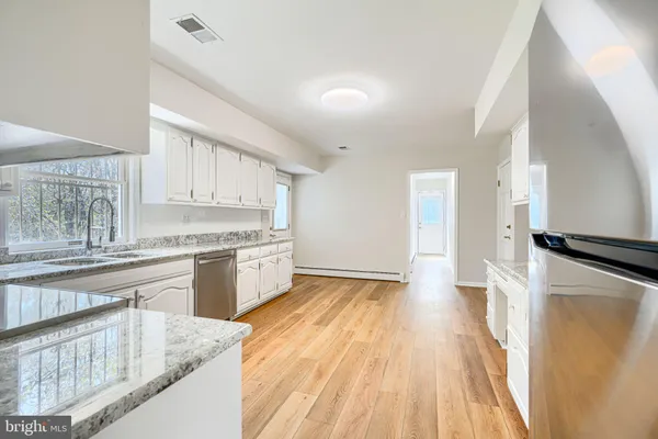 a kitchen with granite countertop a stove top oven sink and cabinets