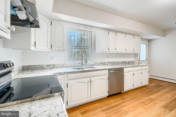 a kitchen with granite countertop a stove top oven and cabinets
