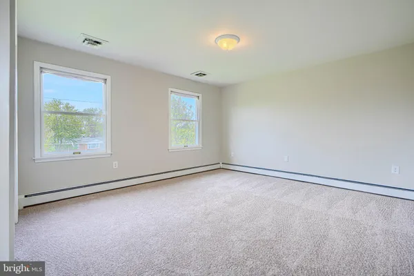an empty room with windows and closet