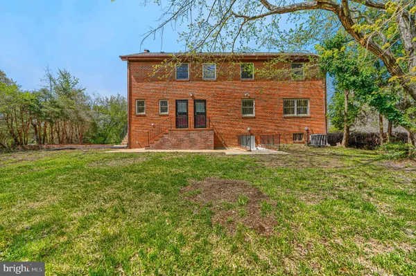 a view of an empty room with wooden floor fireplace and a window