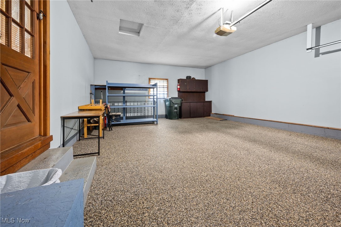 6944 Rolling Ridge Road Northeast Canton, OH 44721 - Photo 22 of 27 Garage featuring a textured ceiling and nature stone floor