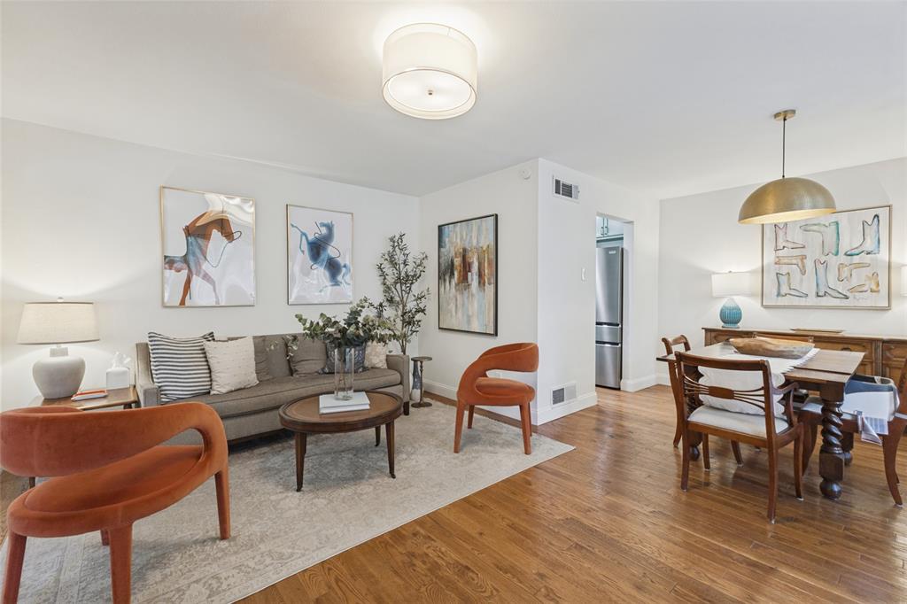 Hardwood flooring throughout, recessed lighting in the living area, and a dining area with a brass pendant light fixture